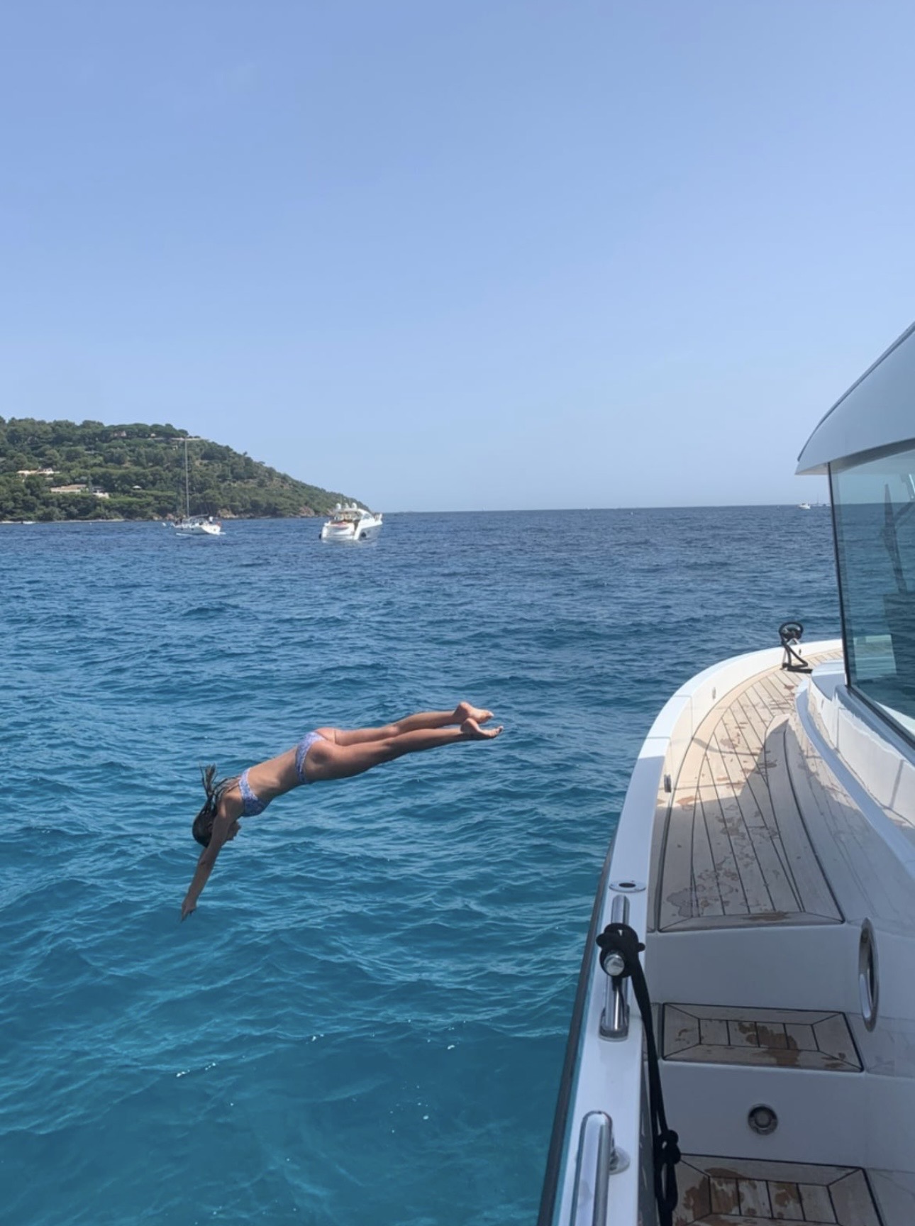 Diving into clear blue water from a boat